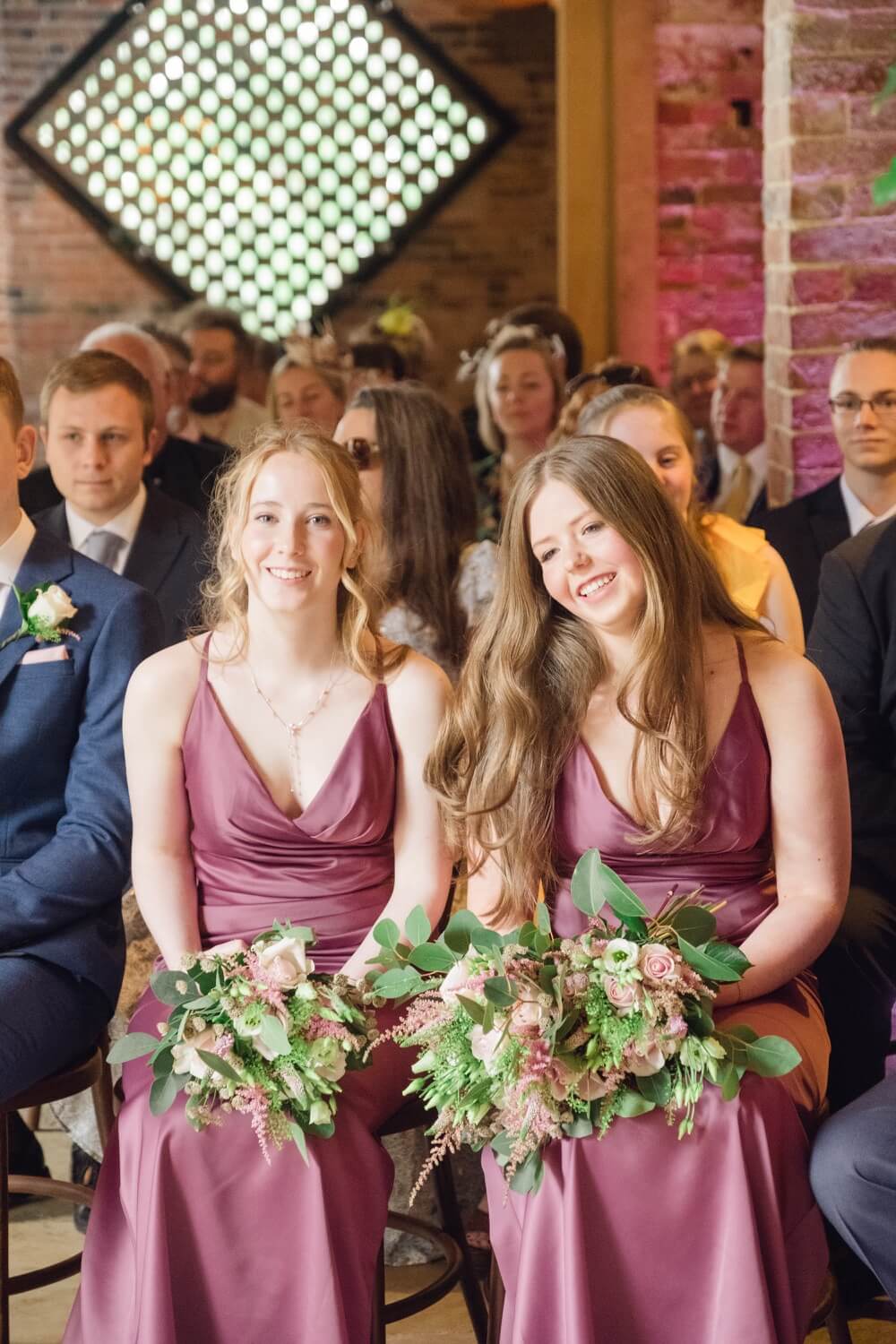 Bridesmaids smiling during the wedding ceremony at Shustoke Barn