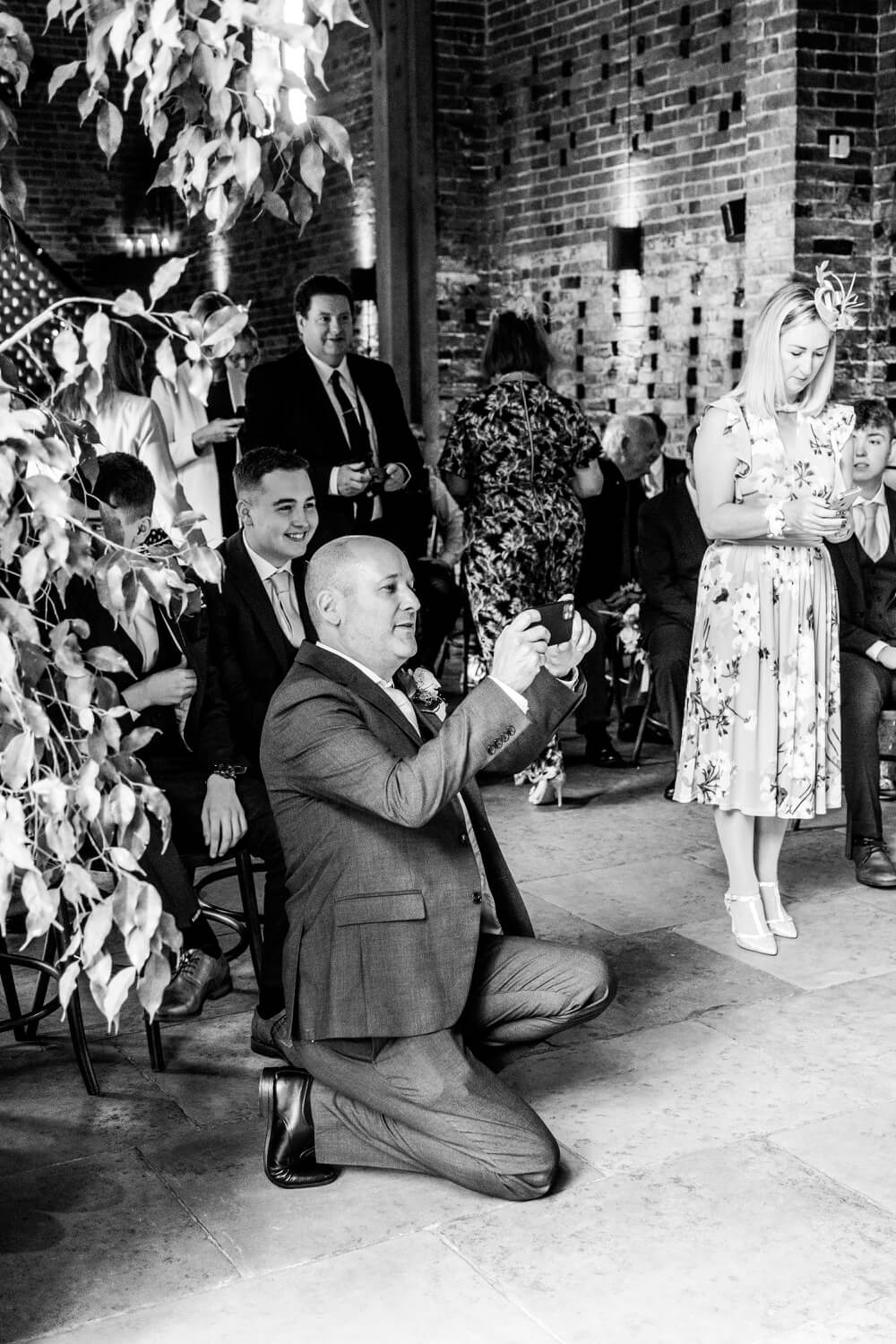 Wedding guest photographing the ceremony on their phone