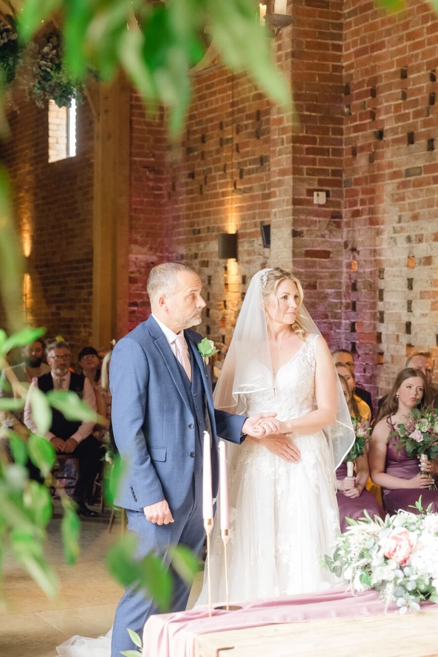 Bride and groom holding hands during their wedding ceremony