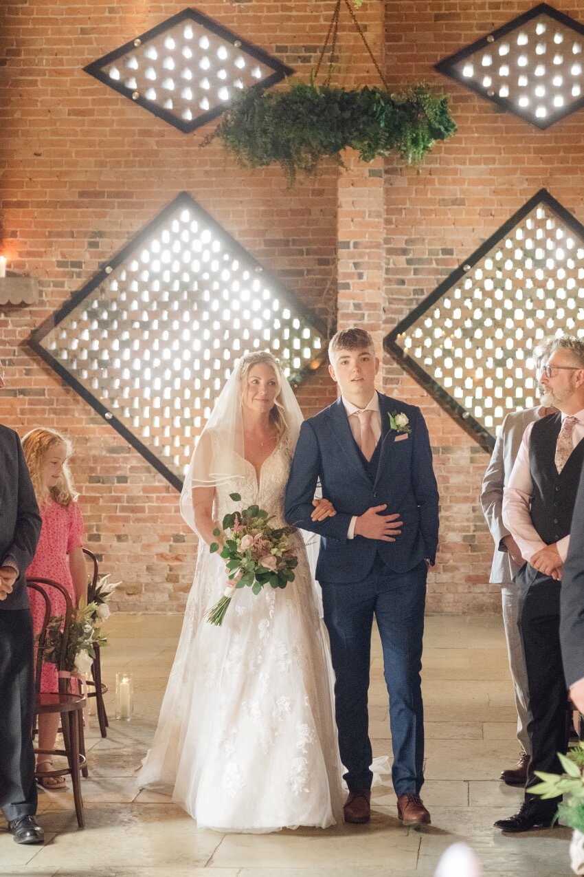 Bride walking down the aisle at her Shustoke Barn wedding ceremony