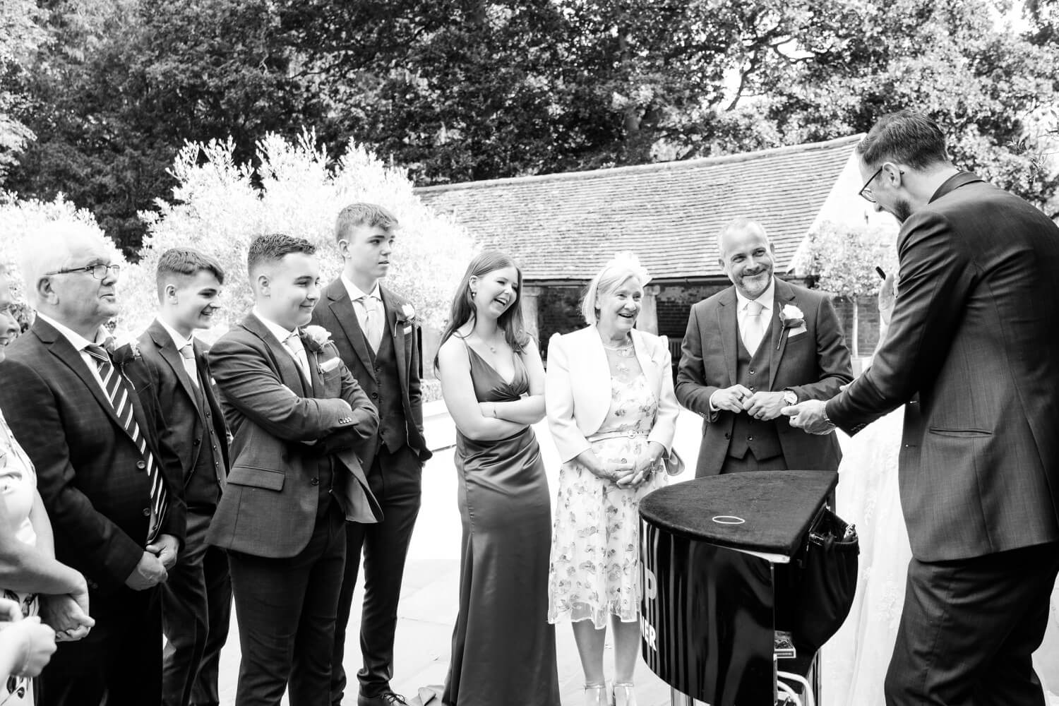 Wedding magician entertaining guests in the courtyard at Shustoke Barn