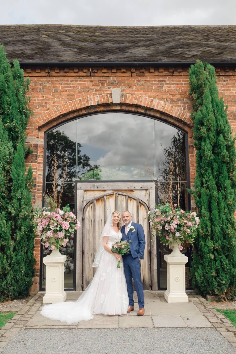 Bride and groom photographed in front of the barn at Shustoke