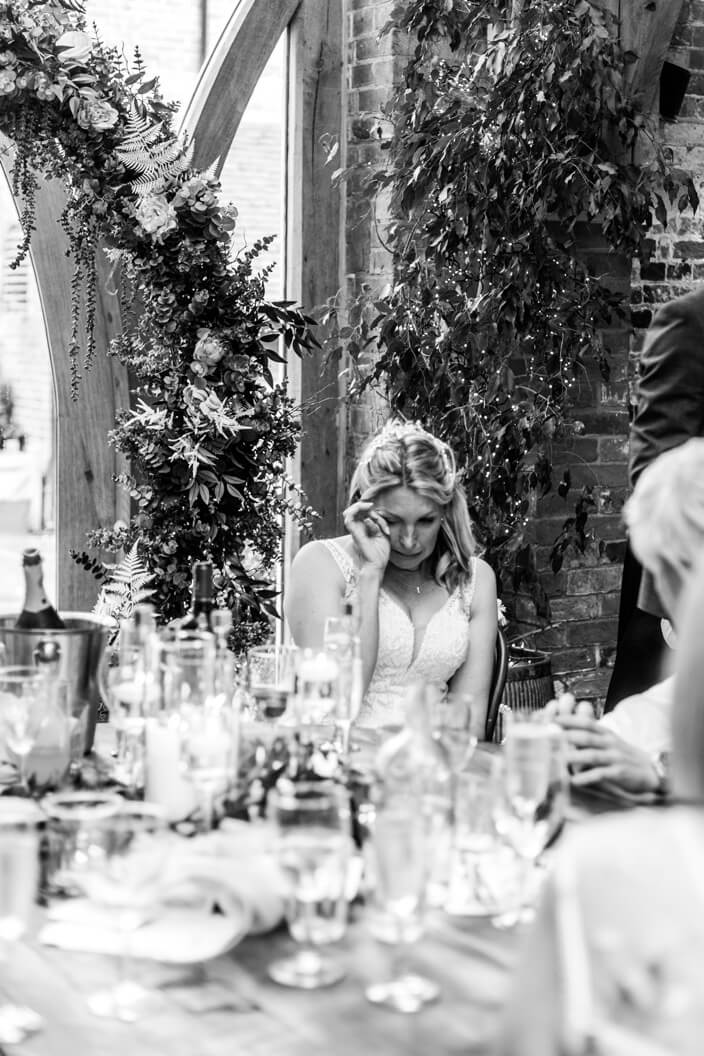 Bride wiping away tears during the wedding speeches