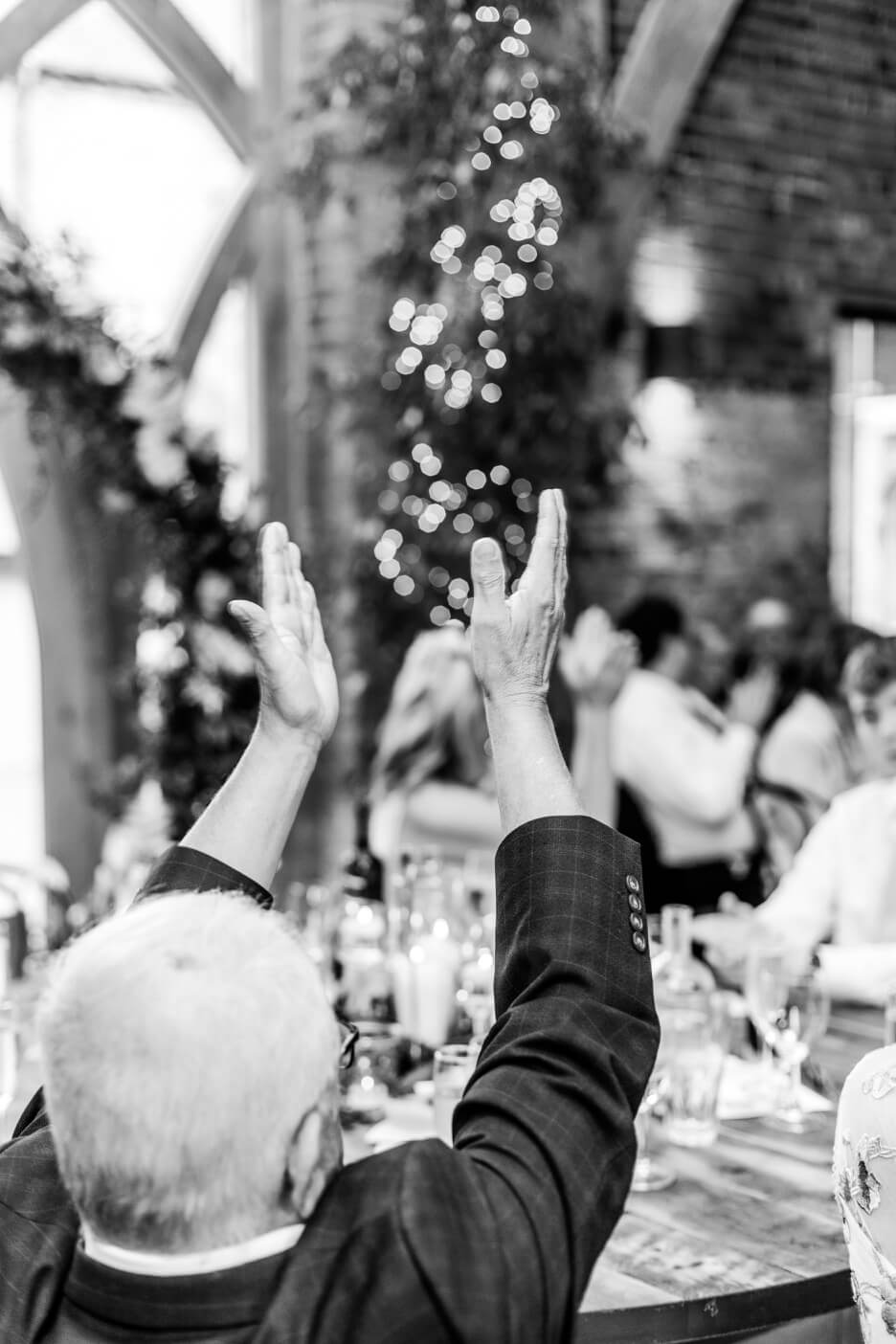 Wedding guest applauding the speeches at Shustoke Barn