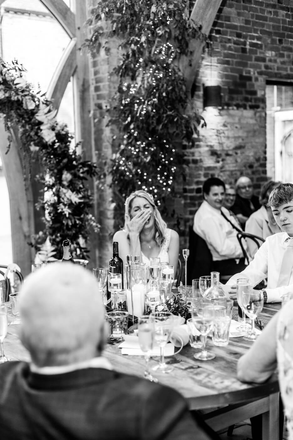Bride laughing during the speeches at her Shustoke Barn wedding