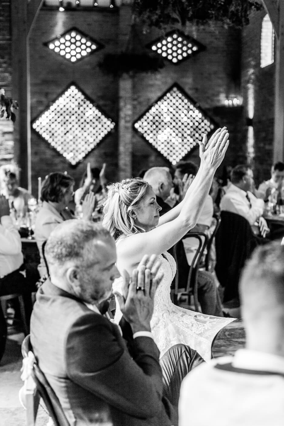 Bride clapping at the end of the speeches at Shustoke Barn