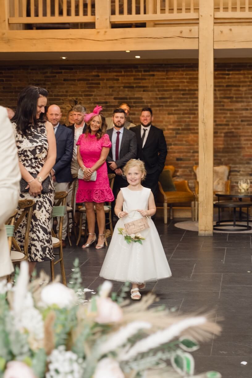 The flower girl coming down the aisle at Mythe Barn