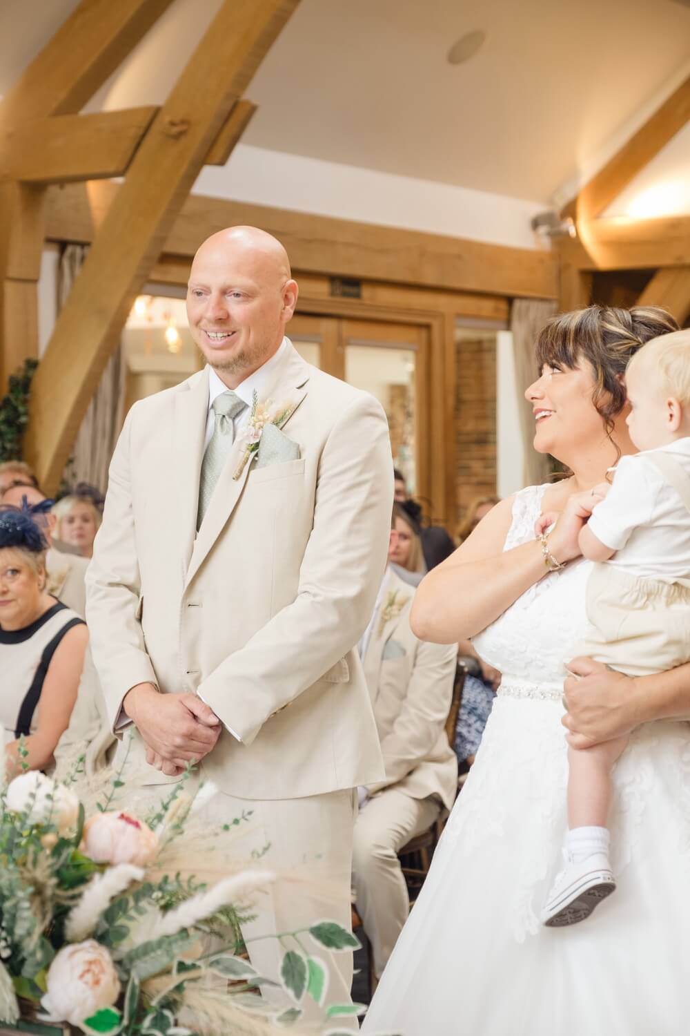 The groom smiling with the bride beside him during the ceremony