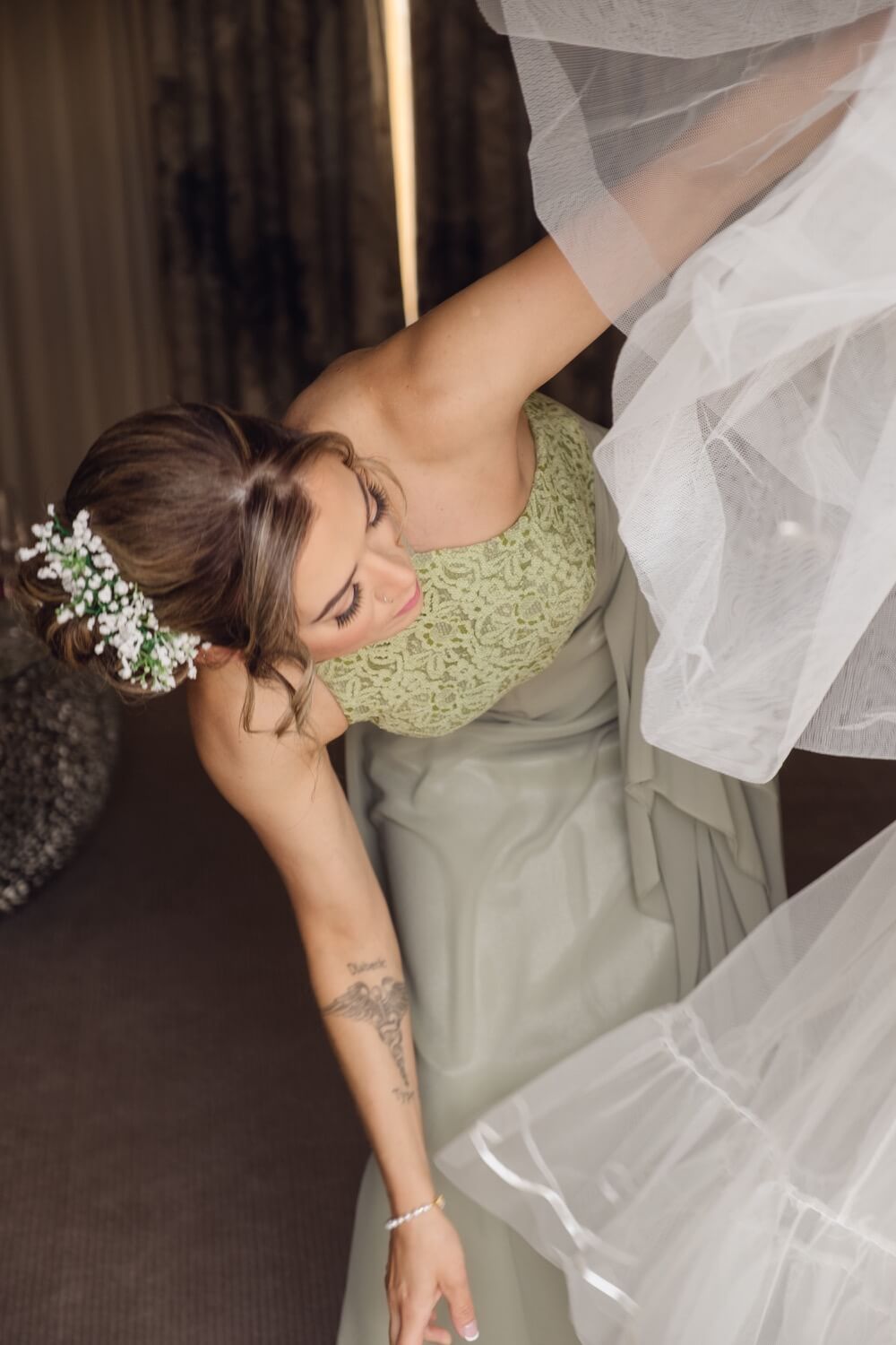 A bridesmaid helping the bride into her dress