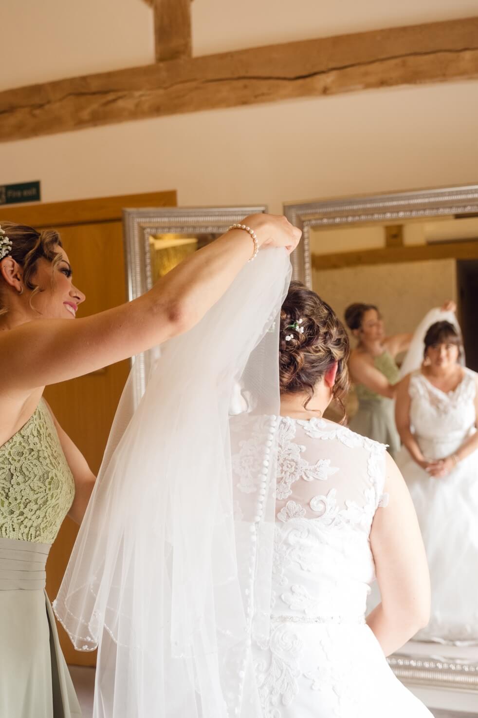 A bridesmaid helping the bride with her veil