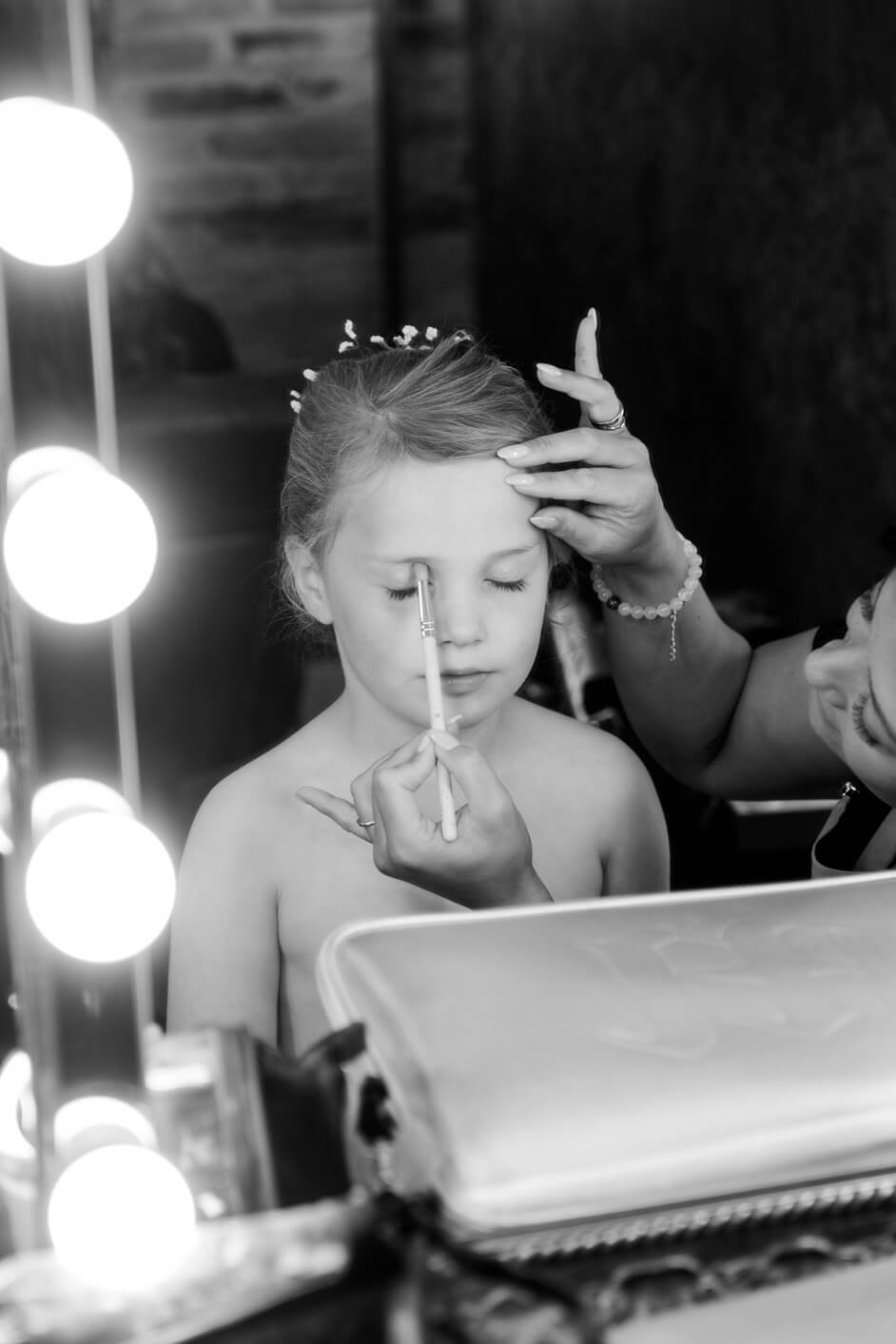 The flower girl having her makeup done