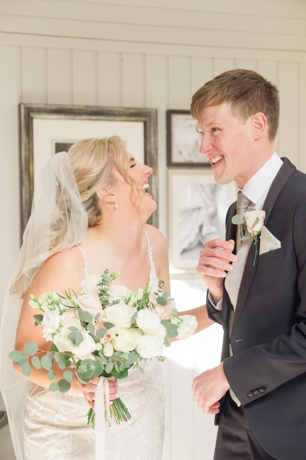 Bride laughing with her brother during preparations