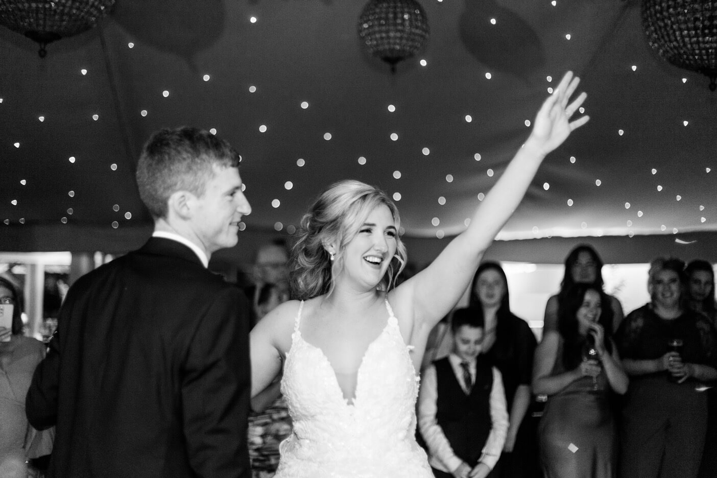 Bride and groom's first dance surrounded by guests