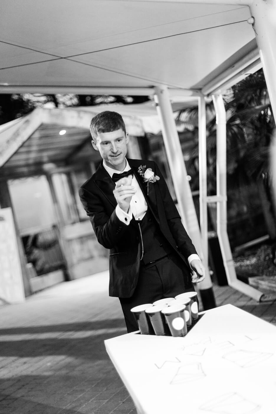 Groom playing beer pong in the Starlit Marquee