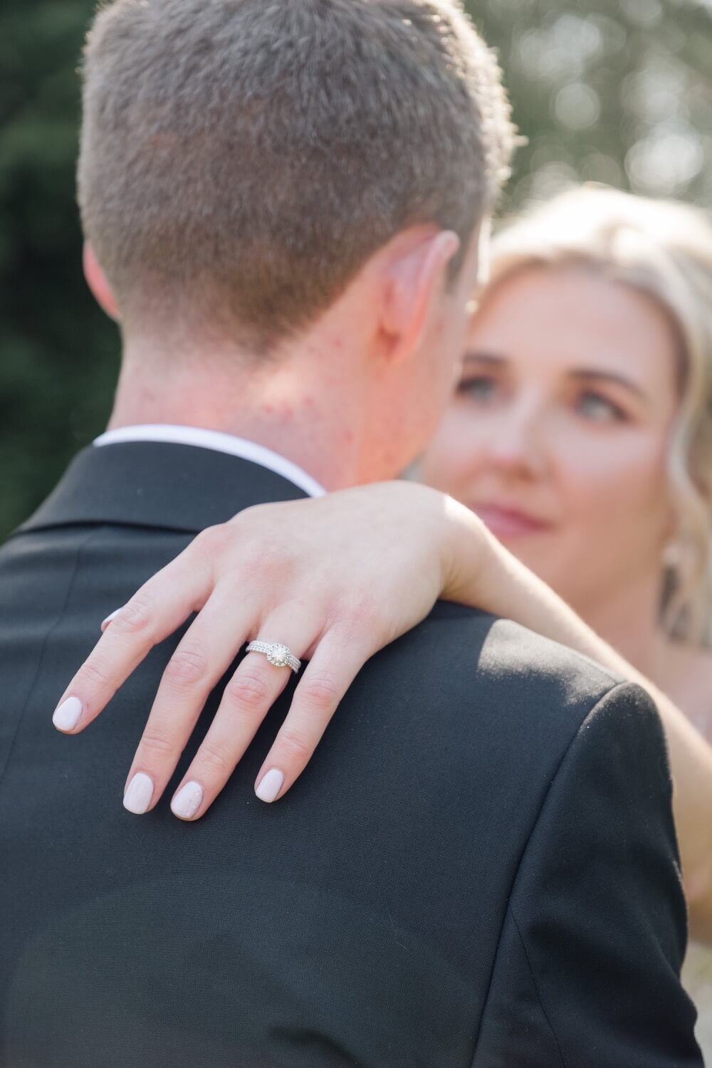 Ring detail, the bride's hand on the groom's shoulder