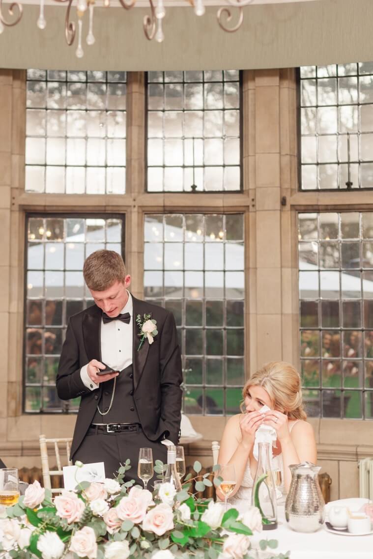Bride wiping away tears during the groom's speech