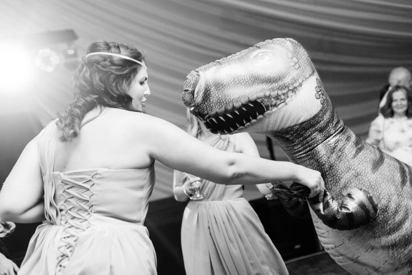A guest dancing with the inflatable dinosaur
