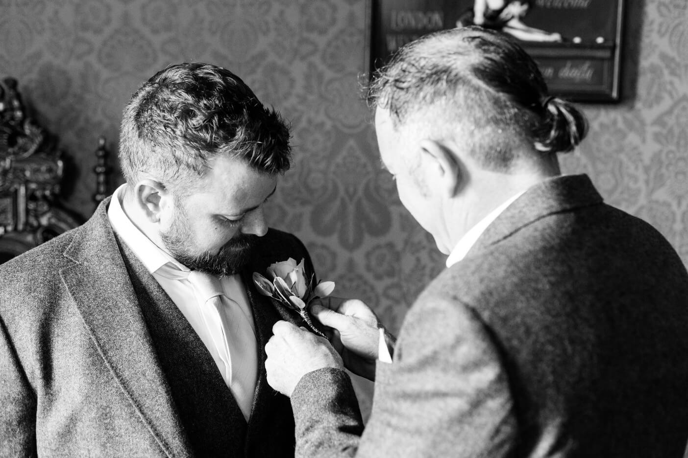 The best man fixing a buttonhole for the groomsmen