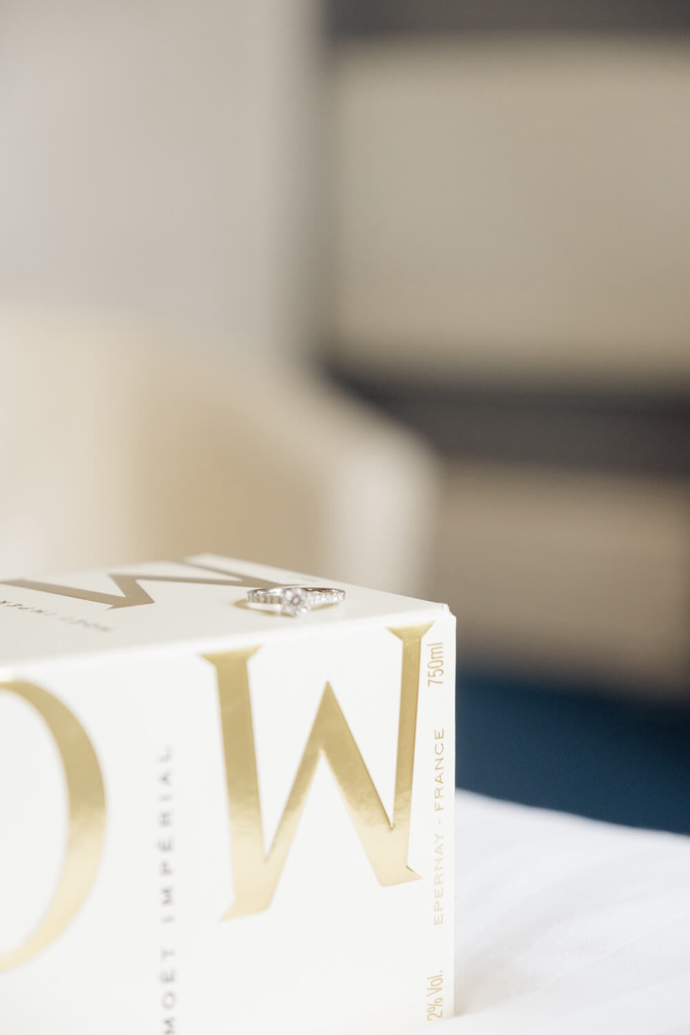 A wedding ring resting on a champagne box
