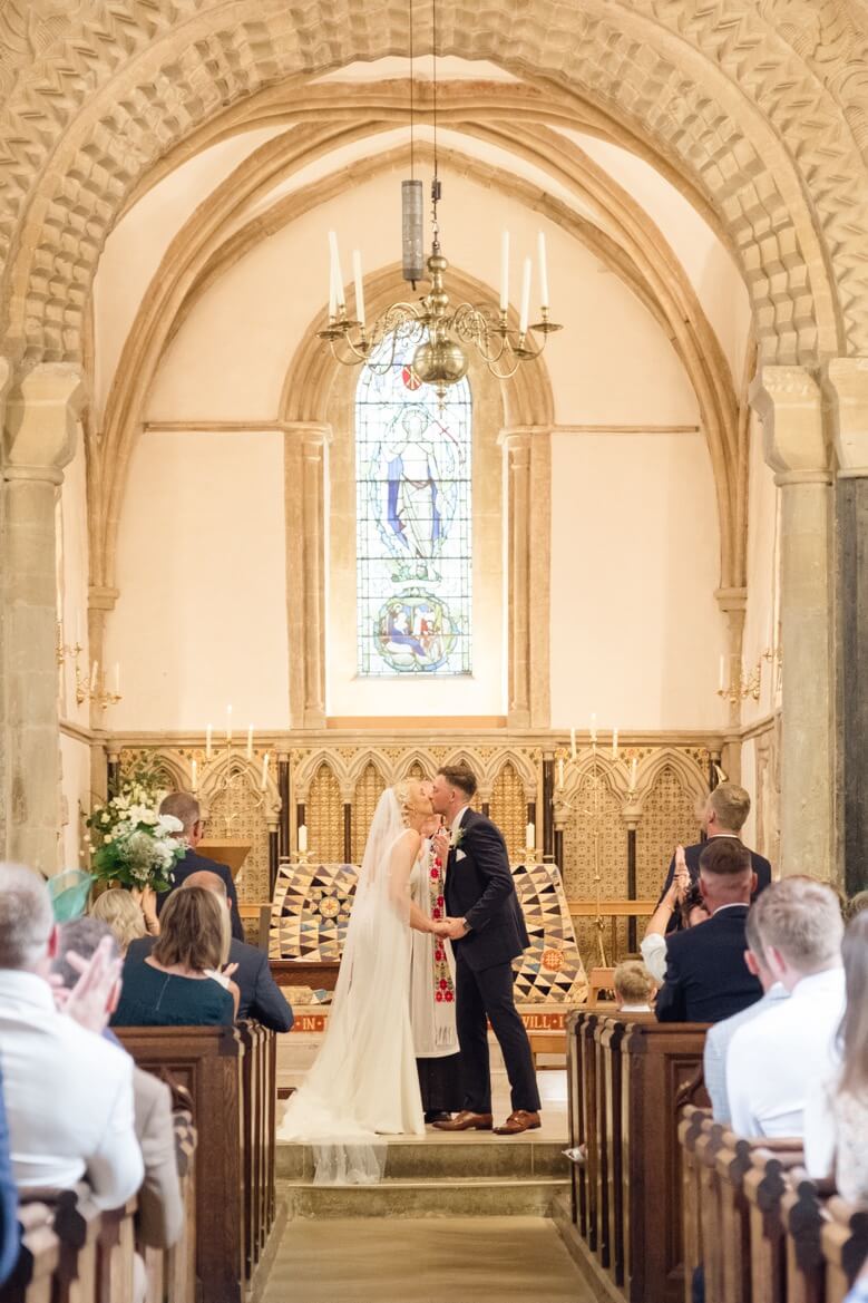 The first kiss during the wedding ceremony near The Great Barn, Aynho
