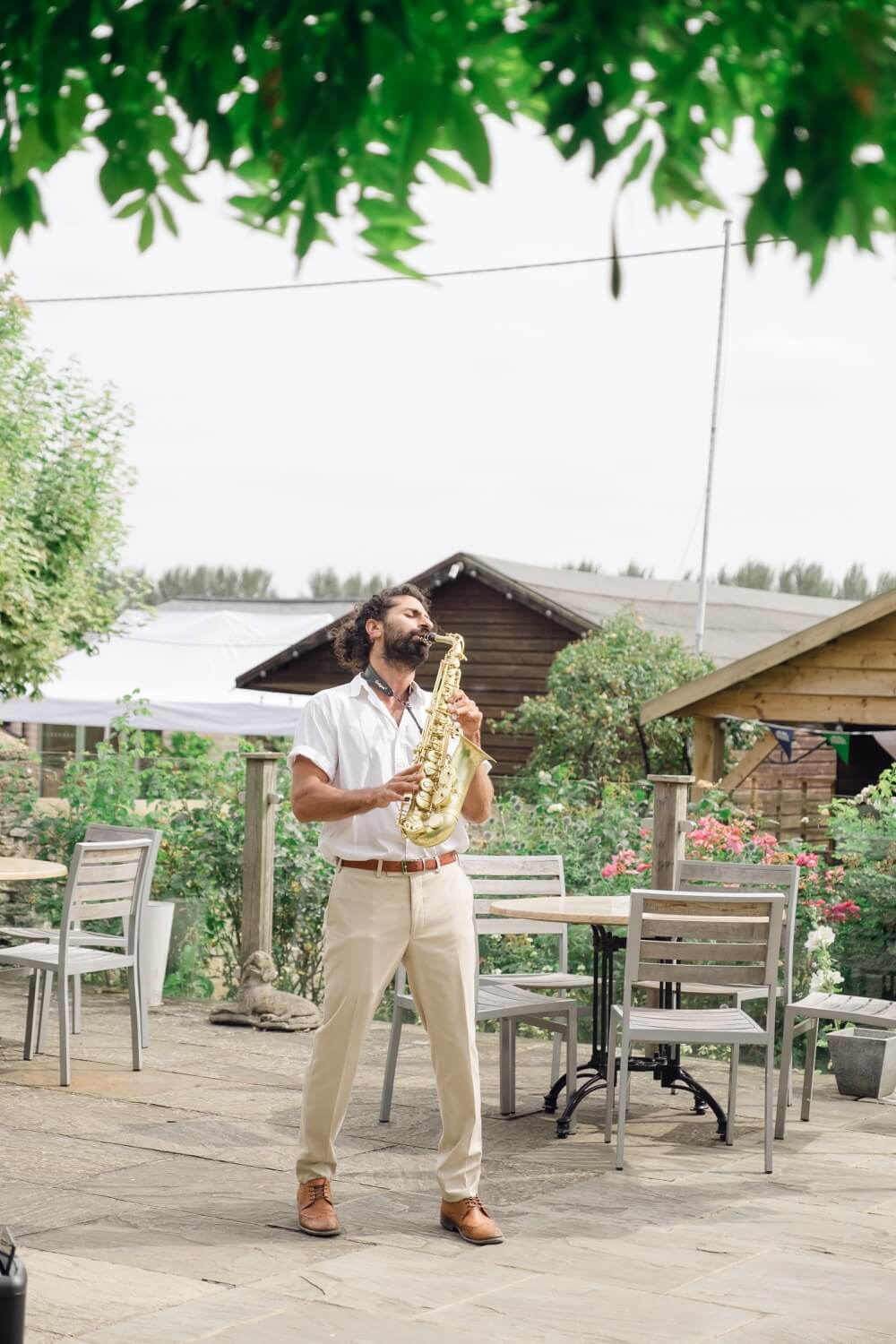 Saxophonist playing during the drinks reception at The Great Barn, Aynho