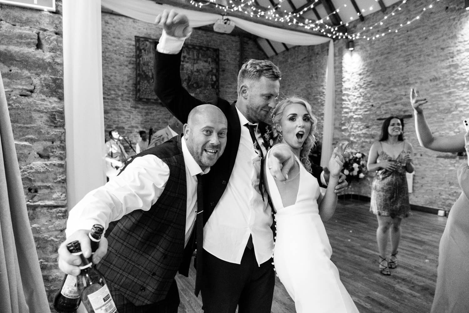 Bride posing with guests during the evening reception at The Great Barn, Aynho