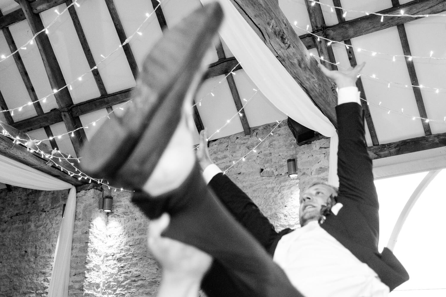Guest lifted on shoulders during the evening reception at The Great Barn, Aynho