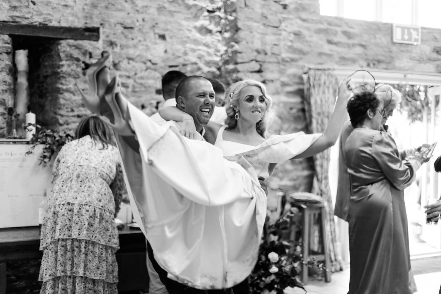 Guest holding the bride on the dance floor at The Great Barn, Aynho