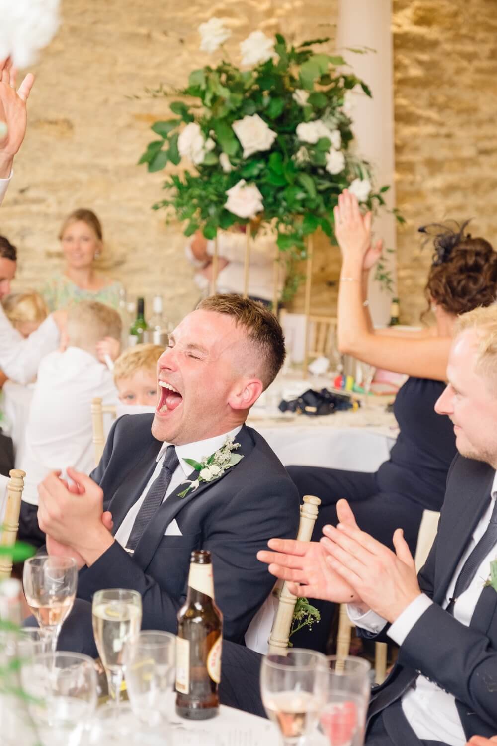 Guest laughing during the best man's speech at The Great Barn, Aynho
