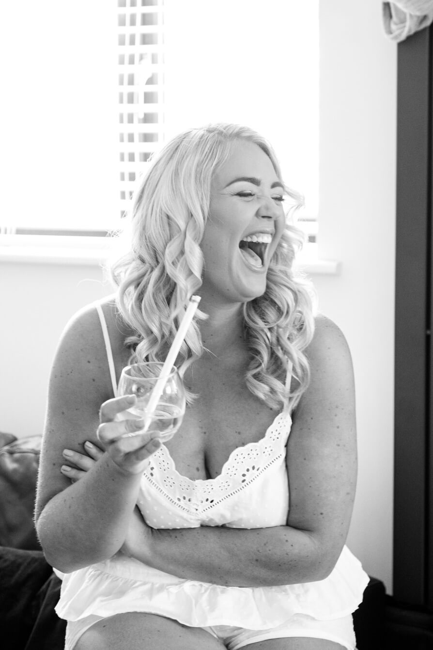 Bridesmaid laughing during getting ready before a Great Barn Aynho wedding