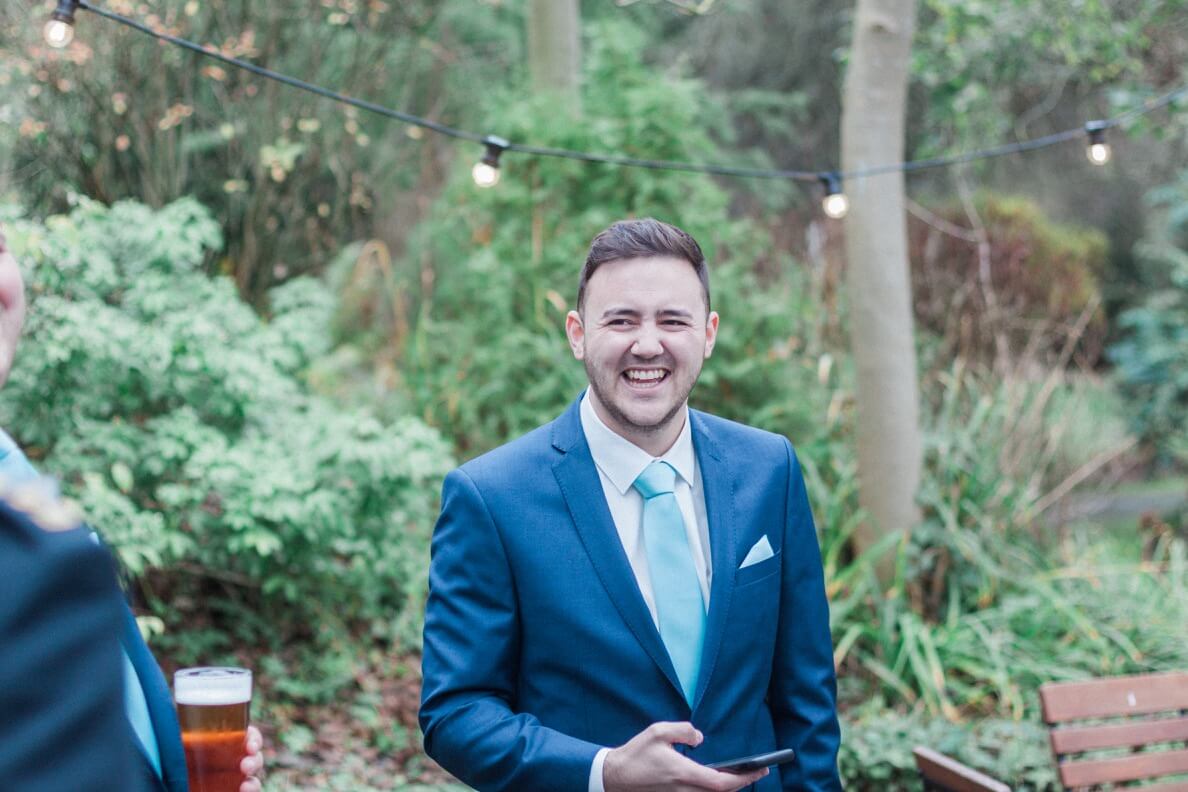 Groom laughing with his groomsmen before the wedding
