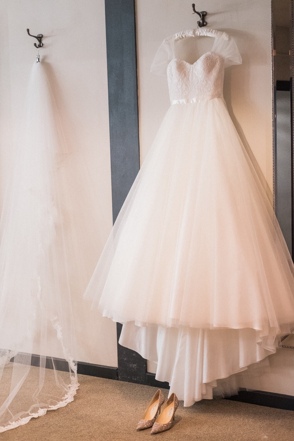 Wedding dress on its hanger with shoes beneath