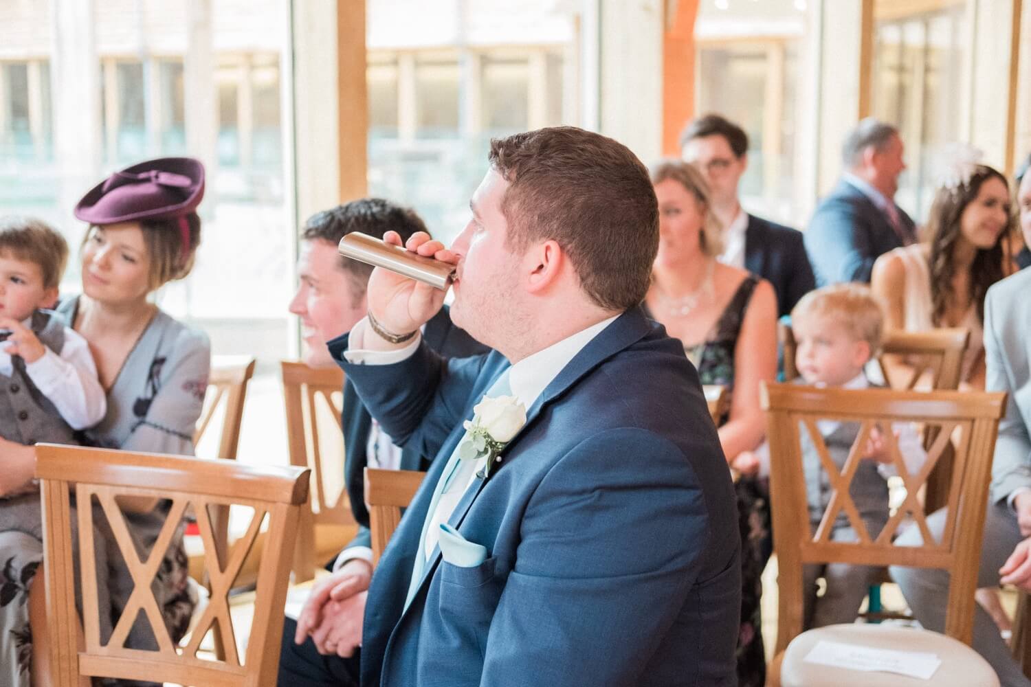 Best man taking a swig from a hip flask before the ceremony