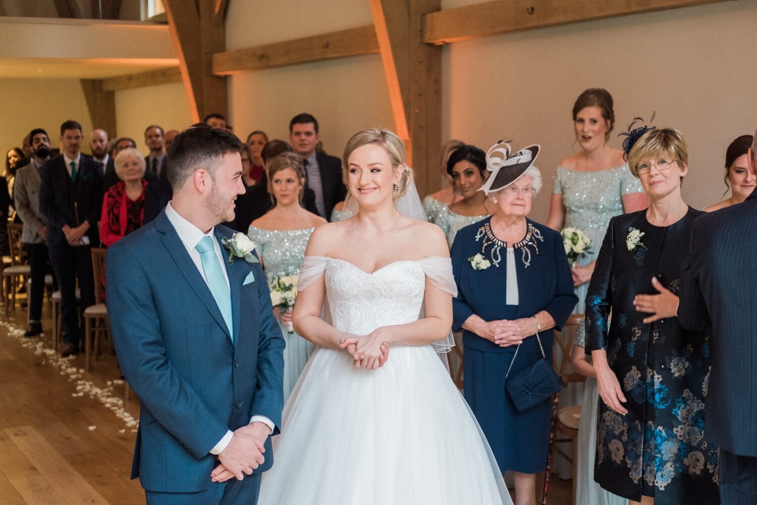 Smiling bride beside the groom during their vows