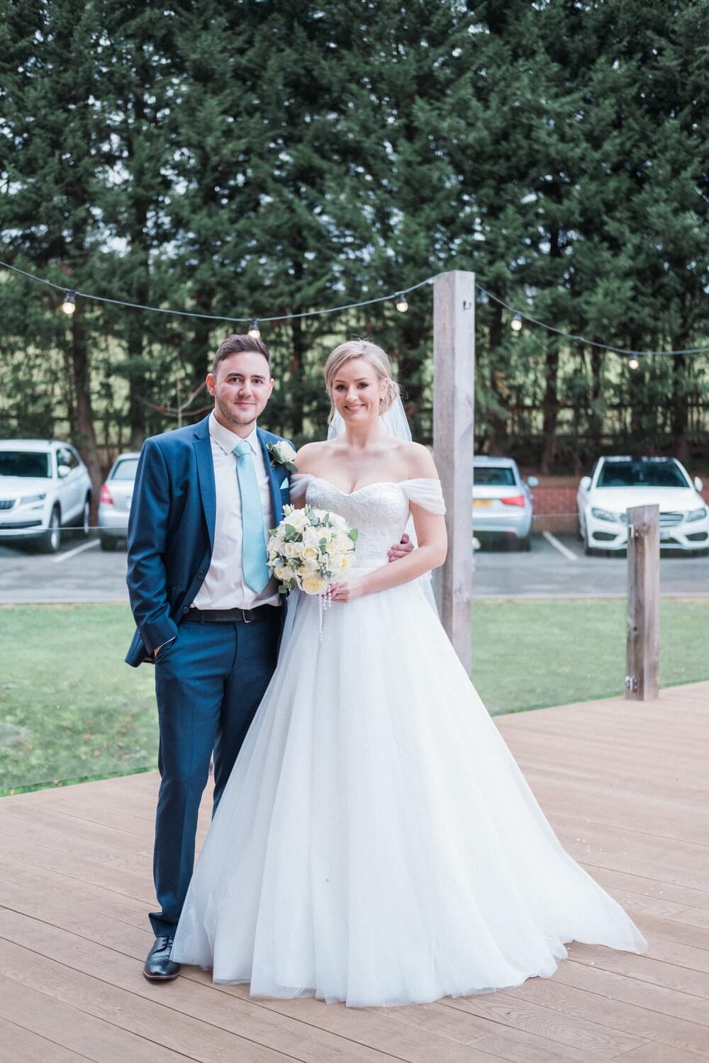 Bride and groom posing on the walkway before the dog surprise