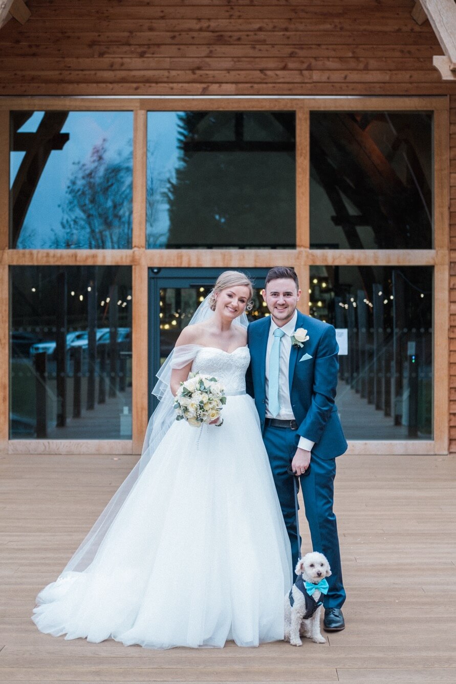 Bride and groom with their dog on the wedding day