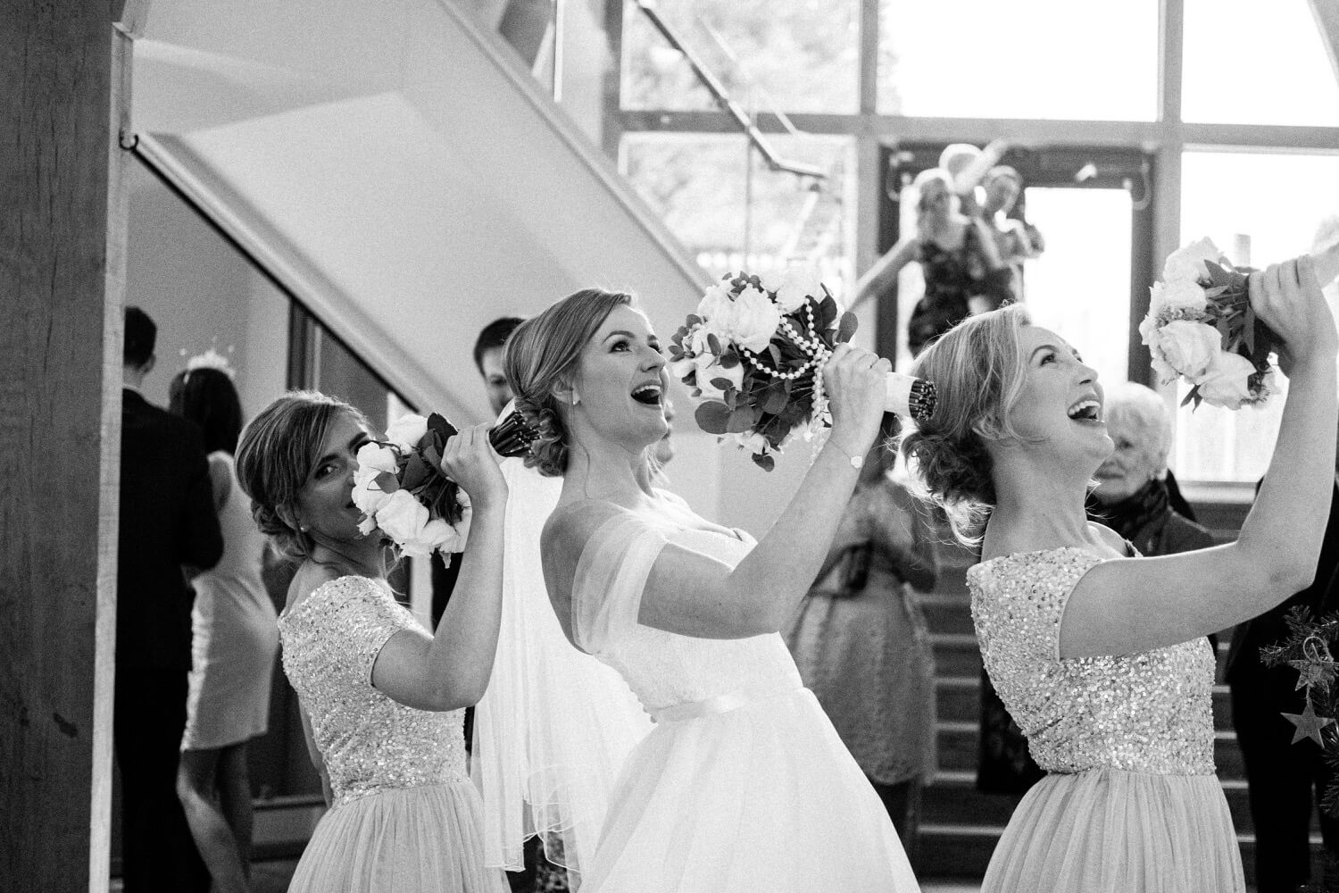 Bride and bridesmaids pulling a funny pose with their bouquets