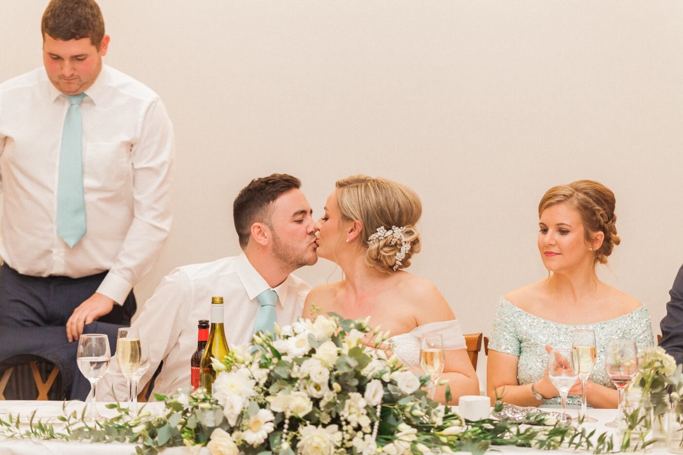 Bride and groom kissing during a speech at The Mill Barns