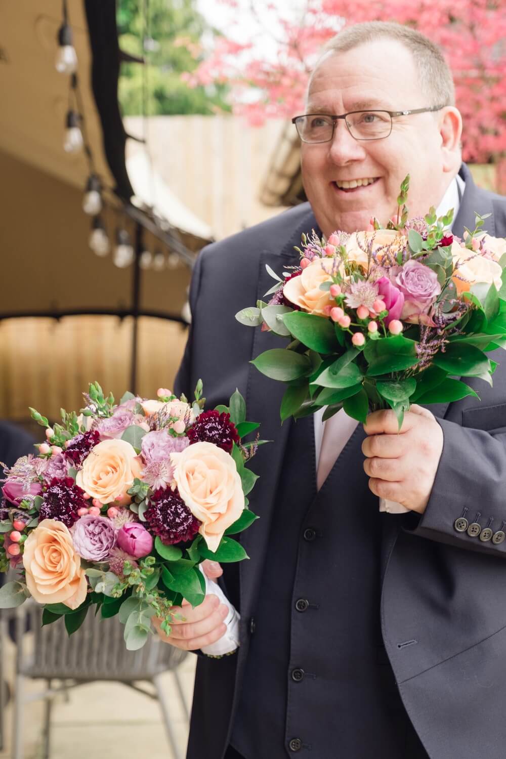 Father of the bride holding two bouquets at The Pear Tree Purton
