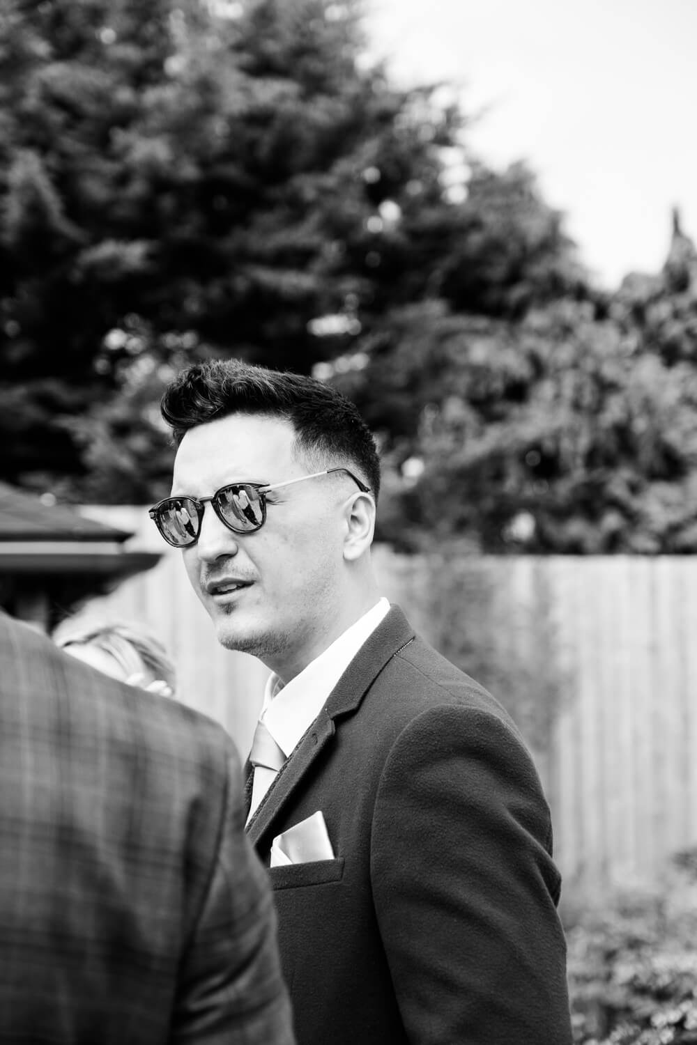 Wedding guest in sunglasses during the drinks reception at The Pear Tree Purton