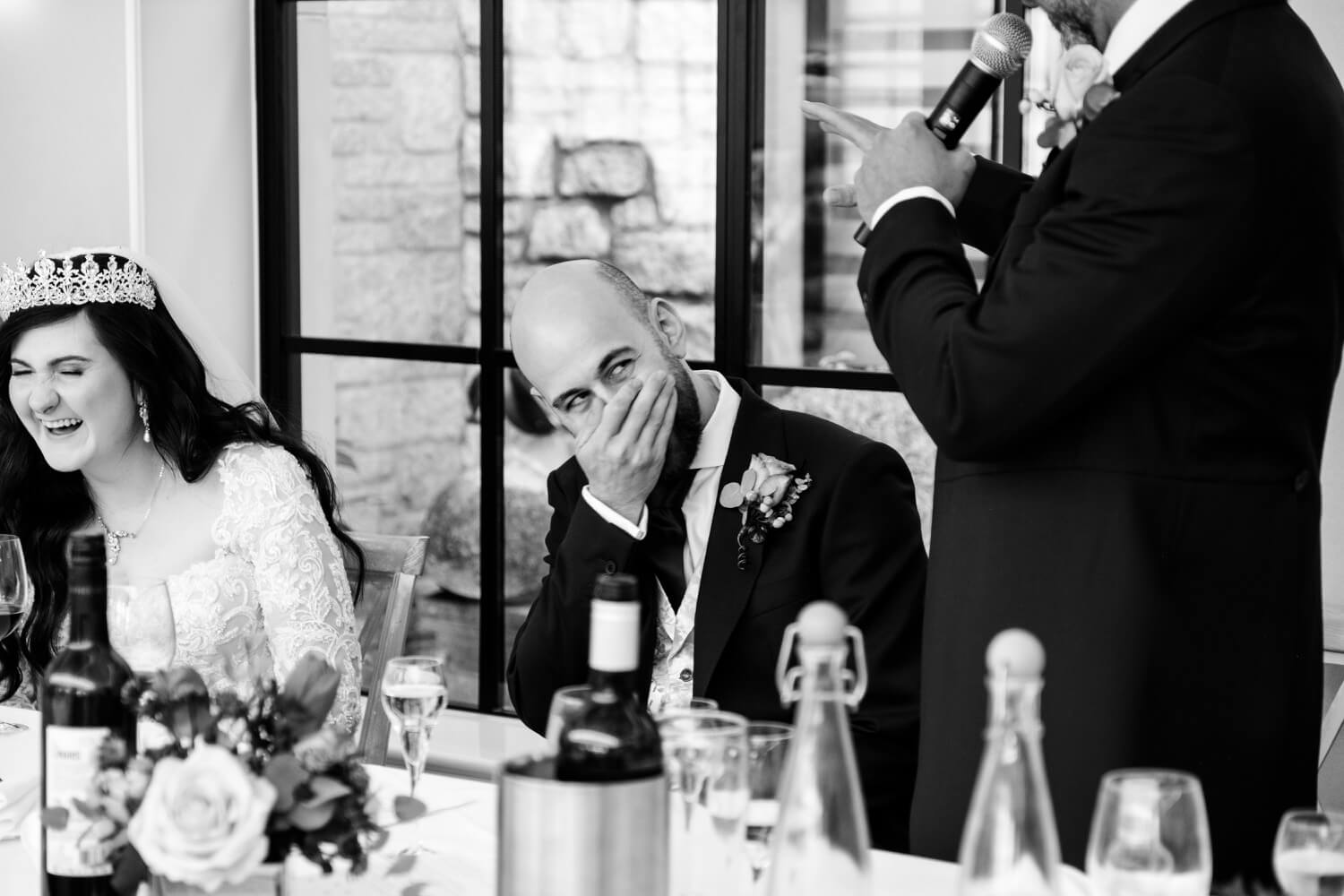 Groom laughing during the best man speech at The Pear Tree Purton