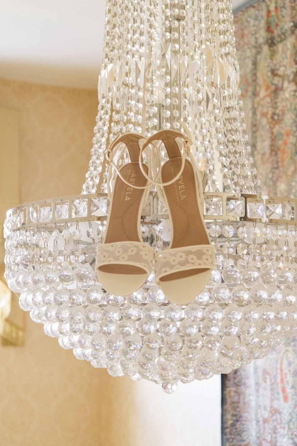 The bride's shoes hanging on a chandelier