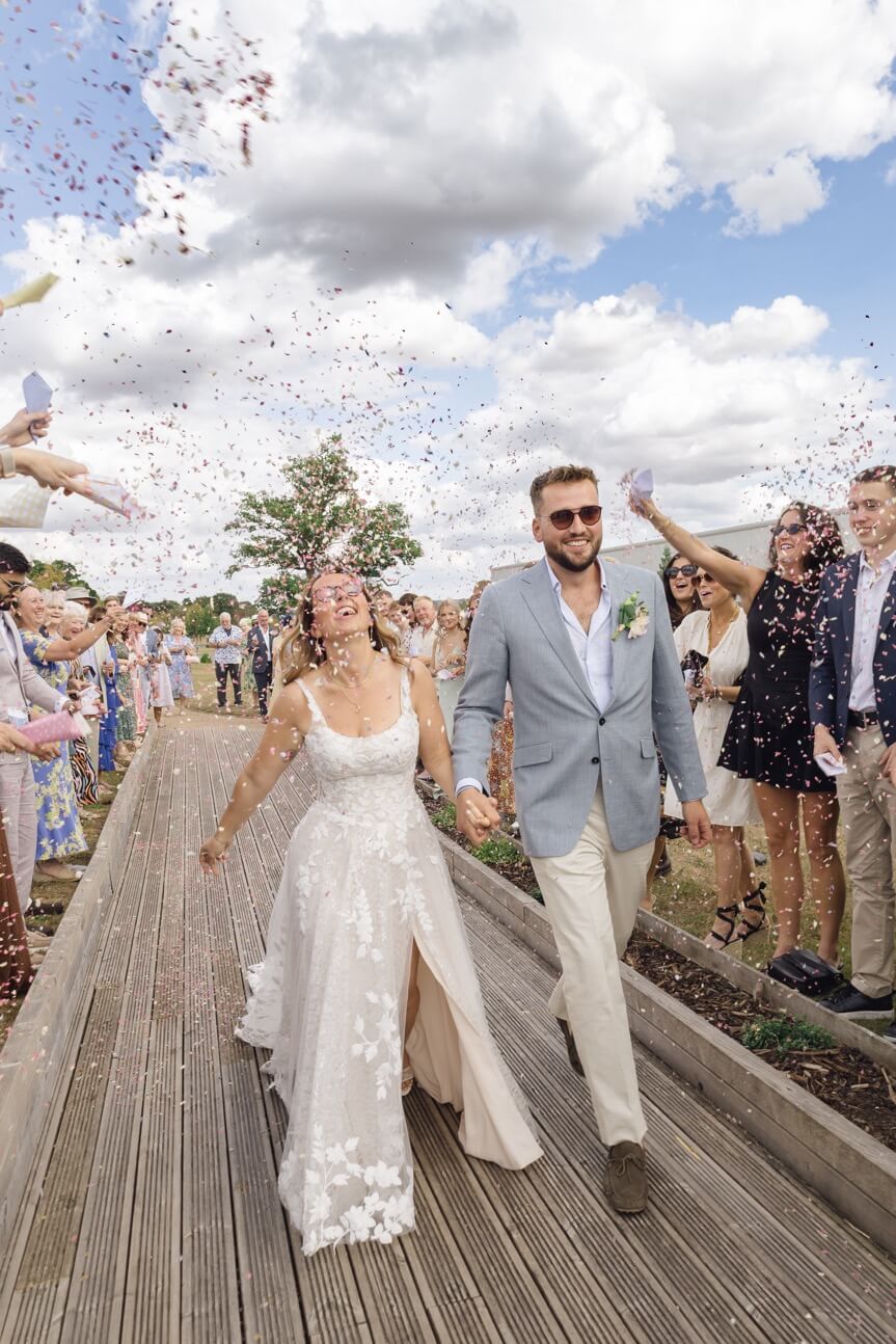 The couple towards the end of the confetti tunnel