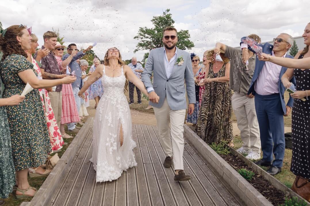 The couple mid confetti at Hencote