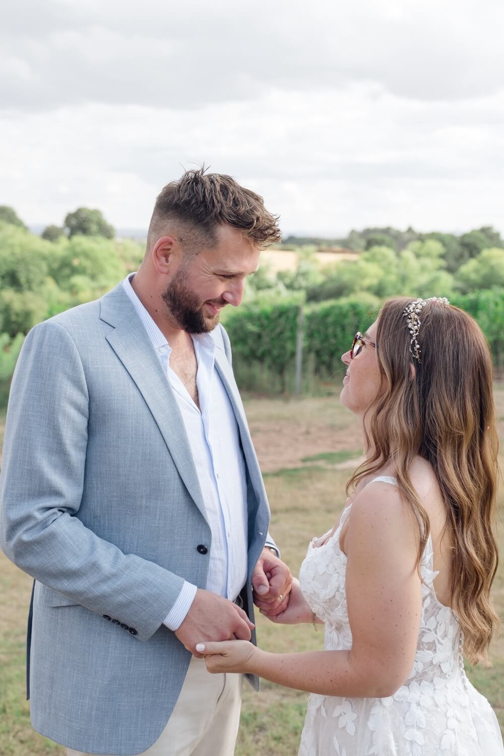 The couple holding hands in the vineyard